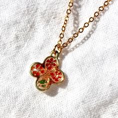 This necklace is composed of a 24k gold plated 16" long chain and features a 12mm vintage enamel floral charm pendant in the shape of a clover. Charm is gold plated, however due to vintage nature, gold karat is unknown. Some may have mild tarnishing on back due to age. Matching earrings available here. Enamel Necklaces With Flower Charm And Pendant, Enamel Flower Pendant Necklace With Charm, Enamel Flower Pendant Necklace With Flower Charm, Vintage Gold Necklaces With Flower Shape, Vintage Gold Flower Shaped Necklace, Gold Flower Necklace With Vintage Charm, Gold Enamel Necklace With Delicate Chain, Gold Enamel Flower Pendant Necklace, Gold Necklace With Vintage Flower Pendant