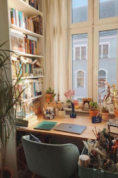 a desk with many books and plants on it