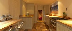 a narrow kitchen with wooden counter tops and white cabinets