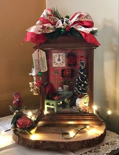 a wooden clock with christmas decorations and lights around it