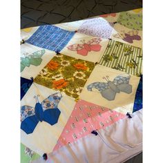 a patchwork quilt with many different designs on it, including butterflies and flowers in pastel colors