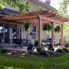 the pergola off the house is being used as an outdoor living area for people to enjoy