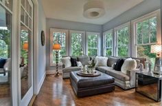 a living room filled with furniture and lots of windows