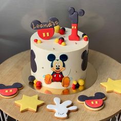 a mickey mouse birthday cake with cookies and decorations