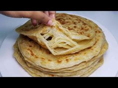 a stack of tortillas on a white plate