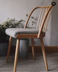 a wooden chair sitting next to a potted plant