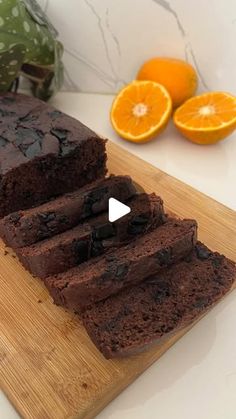 slices of chocolate cake sitting on top of a wooden cutting board next to an orange