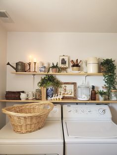 a washer and dryer in a small room with shelves above the washer