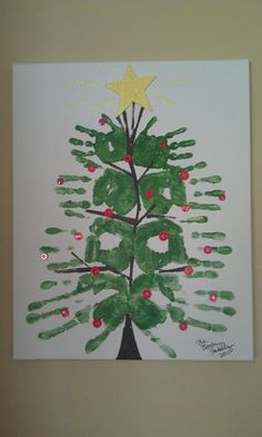 a christmas tree made out of handprints on a white paper with gold star