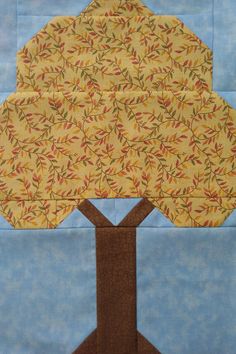 a quilted tree with yellow leaves on it and blue sky in the back ground