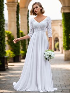 a woman in a white wedding dress standing on a brick walkway with an arch behind her