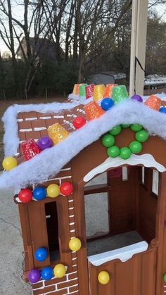 there is a fake gingerbread house with balloons on the roof and snow on the roof