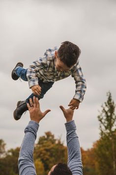 a man holding a child up in the air