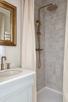 a bathroom with a sink, mirror and shower head in it's corner next to the bathtub