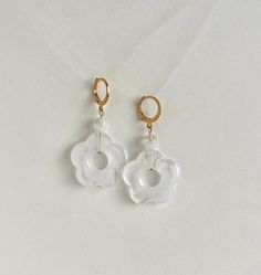 Handmade with white acrylic flower beads, 7mm white glass beads, and 14k gold huggie hoops. These are perfect if you want to add a splash of fun to any outfit, but you forget to take your earrings out before bed and don't like earring posts poking your neck. The lightweight materials don't pull your earlobe or feel heavy.  Made of tarnish resistant 14k gold filled surgical steel to ensure the highest quality without any skin-irritating materials, these are hypoallergenic and 100% lead and nickel free.  2" from top of hoop to bottom of flower. Photos are taken in natural light to try to show the truest colors possible. I love making custom designs, so please message me for custom inquiries or to request an item in a different metal :) I'm a single person business (working to provide better Acrylic Flower, Acrylic Flowers, Earring Posts, Flower Beads, White Acrylic, White Acrylics, Beaded Flowers, Flower Earrings, White Glass