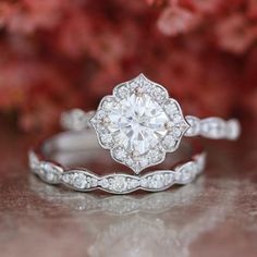 an engagement ring with a flower design on the side and a diamond in the middle