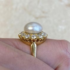 This beautiful ring features a natural saltwater button pearl weighing 21.48 chows. The pearl is adorned with a halo of old mine cut diamonds, which form a floral design and have a total approximate weight of 1.44 carats. This ring is handcrafted in 18k yellow gold.
The measurements of the natural pearl are 10.4mm. The measurements of this ring are 16.67mm x 16.82mm including the diamond halo.
This ring can be resized to any finger size at no extra cost.
If you have any questions about the Bayvi Classic Oval Diamond Pearl Ring, Timeless Oval Pearl Ring With Brilliant Cut, Victorian Pearl Ring With Diamond For Anniversary, Heirloom Oval Pearl Ring With Rose Cut Diamonds, Heirloom Oval Pearl Ring With Brilliant Cut, Classic Pearl Ring With Diamond Halo Setting, Luxury Pearl Ring With Rose Cut Diamonds For Anniversary, Luxury Round Pearl Ring With Halo, Classic Halo Pearl Ring