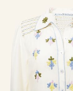 Cut from Tencel, our pastel floral embroidery white shirt has a hand-smocked placket and short length. The long-sleeved shirt is hand-embroidered along the front, collar, and smocked cuffs. Incredibly soft, the shirt has a beautiful drape and an sheer texture in the swaths of white. This one-of-a-kind textile was embroidered by hand. Subtle variations are part of the unique beauty of the garment and a signature of the artisan's hand. Sheer Texture, Smocked Blouse, Smock Blouse, Shirt Embroidery, Unique Beauty, Cheese Cloth, Beautiful Drapes, Pastel Floral, Floral Embroidery