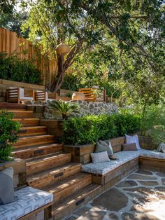 an outdoor seating area with stone steps and trees