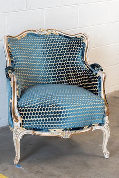 a blue and white chair sitting in front of a brick wall with yellow lines on it