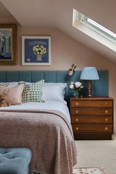 a bedroom with pink walls and blue bedding in the corner is decorated with flowers