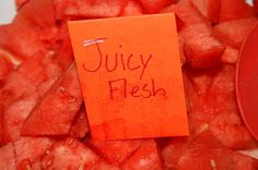 a pile of sliced watermelon with a note attached to the top that says juicy fresh