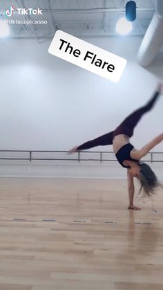 a woman doing a handstand on top of a hard wood floor