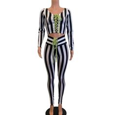 a female mannequin dressed in black and white striped clothing with green tie around the waist