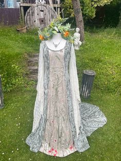 a white dress with flowers on it sitting in the grass