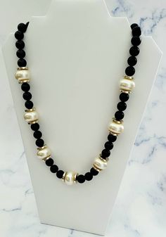 Vintage Faux Pearl and Black Bead with Gold Tone Spacers Necklace *BOLD* Condition: Pre-owned, very good to excellent! Measurements: 24 inches long and larger faux pearl beads are 1 inch in diameter and black beads are 0.5 inches in diameter Fantastic example of a vintage 1960's to 1970's bold ivory faux pearl and black beaded with gold tone disc spacers form a single strand statement necklace. This striking piece will add interest and glamour to your outfit day or night! Unsigned beauty~ FREE S Diy Beaded Necklaces, Diy Christmas Earrings, Diy Jewelry Unique, Beaded Necklace Designs, Beaded Necklace Diy, Beads Bracelet Design, Eyeglass Chain, Coral Jewelry, Beaded Choker