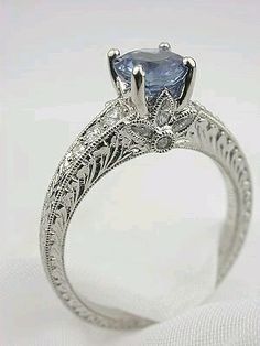 an antique style engagement ring with a blue stone in the center