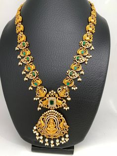 Goddess Lakshmi Green Stone CZ Peacock Pattern Long Necklace with matching screwback earringsColor : GoldenSize : Necklace Length : 24 Inches; Earring Length 2.5 inchesStones : Red Green Stone CZ Pearls Necklace Traditional, Long Haram, Traditional Necklace, Temple Jewelry, Peacock Pattern, Goddess Lakshmi, Temple Jewellery, Green Stone, Necklace Length