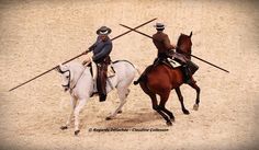 two men riding horses with spears on their backs