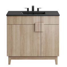 a bathroom vanity with black counter top and wooden cabinet doors on one side, two faucets on the other