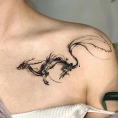 a woman with a dragon tattoo on her shoulder