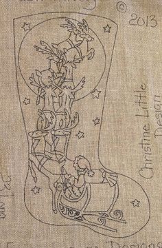 an embroidered christmas stocking with santa claus and his sleigh in the center