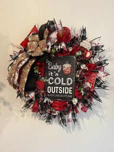 a baby it's cold outside wreath hanging on the wall