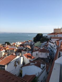 the rooftops and buildings are all white with red roof tops, overlooking the ocean