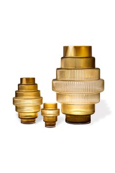 three stacks of golden glass candlesticks on a white background