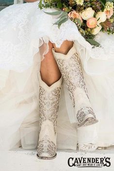 a woman in cowboy boots and wedding dress with flowers on her head is sitting down