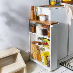 an open cabinet in the corner of a kitchen with spices, nuts and other items