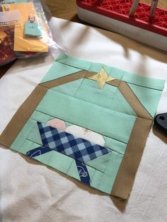 a piece of fabric on top of a table with scissors and other crafting supplies