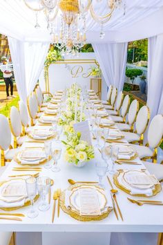 the table is set with white and gold place settings