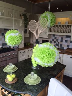 some tennis rackets hanging from the ceiling in a kitchen with green decorations on it