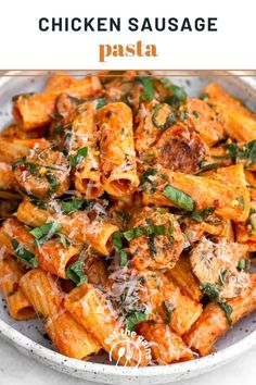 chicken sausage pasta in a white bowl with parmesan cheese and herbs on top