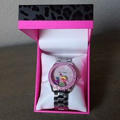 a watch in a pink and black box with leopard print on the inside, sitting on a table