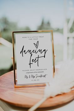 the guest book is placed on top of a wooden table with a white feather in it