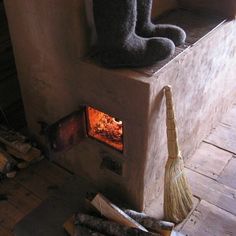 an oven with a broom in front of it and a stuffed animal sitting on top