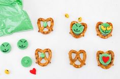 some pretzels with faces on them and candy in the shape of heart shapes