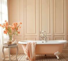 a pink bath tub sitting next to a white table with flowers in the vase on it